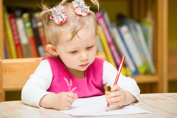 Cute child girl drawing with colorful pencils in preschool at the table in kindergarten — Stock Photo, Image