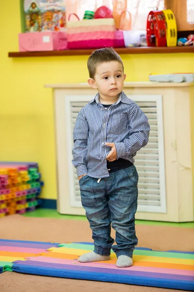 Маленький мальчик играет в детском саду — стоковое фото