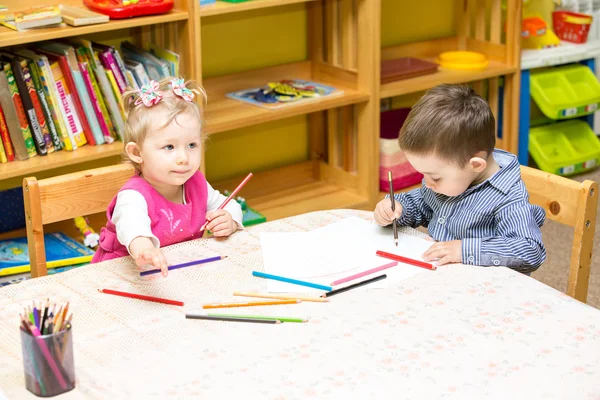 Dos niños pequeños dibujando con lápices de colores — Foto de Stock