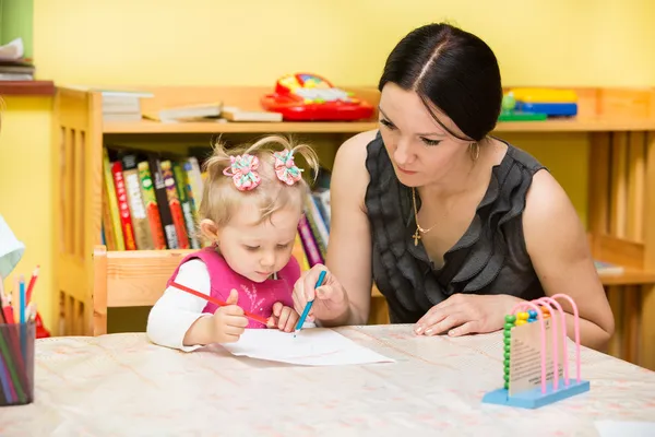 Matka i dziecko dziewczynka grający w przedszkolu w klasie przedszkola montessori. — Zdjęcie stockowe