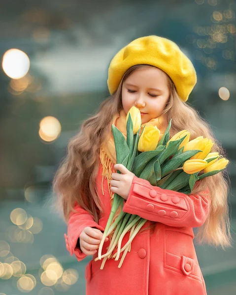 Porträt eines glücklichen Mädchens mit einem Strauß gelber Tulpen auf einem Frühlingsspaziergang. Blumen zum Internationalen Frauentag. — Stockfoto