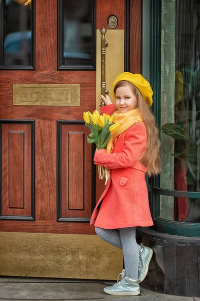 Portrait of a happy girl with a bouquet of yellow tulips on a walk in spring. Flowers for International Womens Day. — Stockfoto