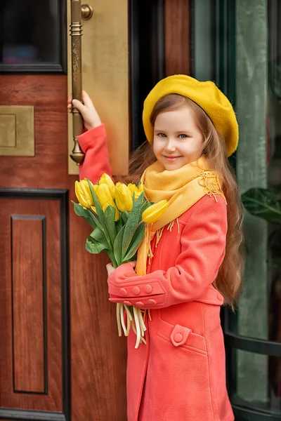 Portrét šťastné dívky s kyticí žlutých tulipánů na procházce na jaře. Květiny pro Mezinárodní den žen. — Stock fotografie