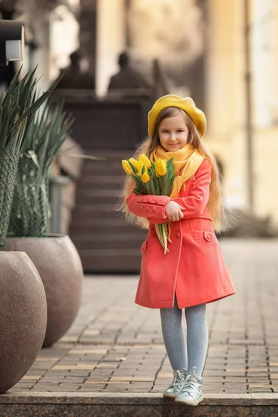 Porträt eines glücklichen Mädchens mit einem Strauß gelber Tulpen auf einem Frühlingsspaziergang. Blumen zum Internationalen Frauentag. — Stockfoto