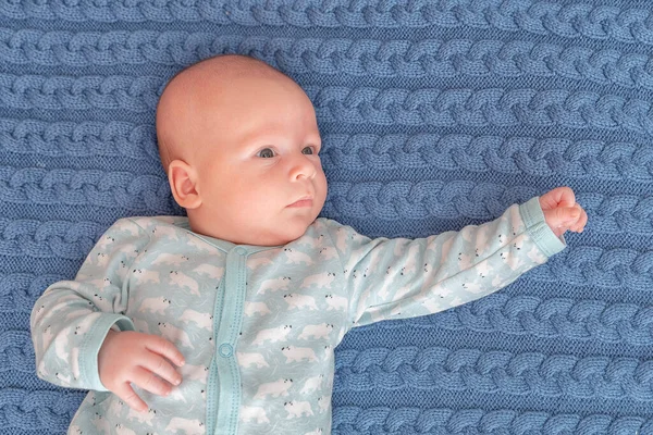 3 aylık şirin bir bebeğin portresi, kötü bir vaziyette yatan yeni doğmuş bir çocuk. Yeni doğmuş çocuk yatak odasında dinleniyor. Evde aile sabahı vakti..