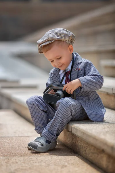 外のステップでレトロなヴィンテージフォトカメラで写真を撮る小さな男の子の写真家の肖像画 子供たちの写真撮影 子供時代のライフスタイルのコンセプト — ストック写真