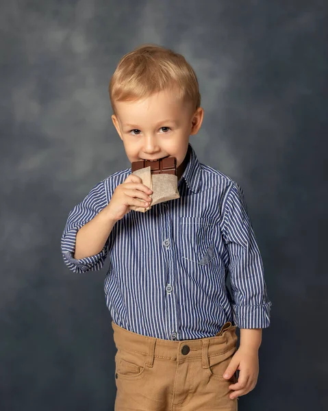 Ritratto Ragazzino Che Mangia Cioccolato Sfondo Grigio Concetto Infanzia Felice — Foto Stock