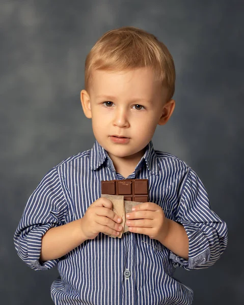 Porträt Eines Kleinen Jungen Der Schokolade Auf Grauem Hintergrund Isst — Stockfoto