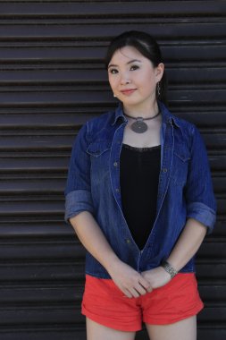 Asya model garaj kapısı önünde poz.