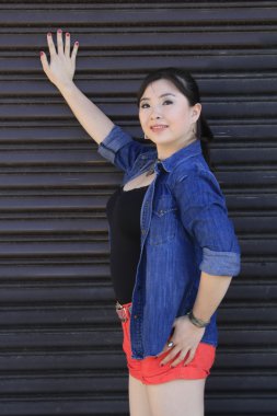 Asya model garaj kapısı önünde poz.