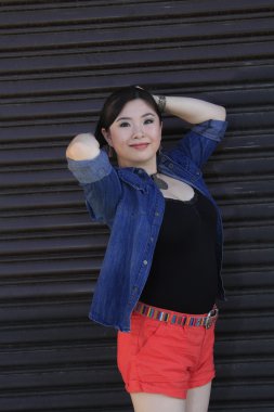 Asya model garaj kapısı önünde poz.