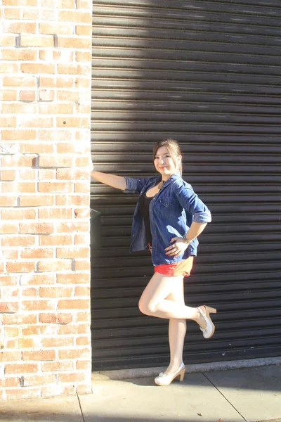 Asian model posing in front of garage door. — Stock Photo, Image