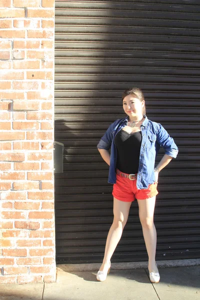 Modelo asiático posando na frente da porta da garagem . — Fotografia de Stock