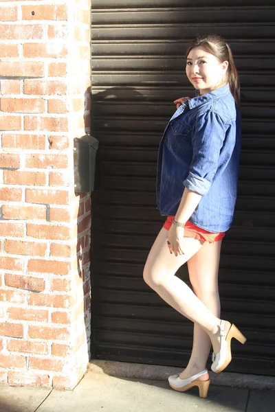 Asian model posing in front of garage door. — Stock Photo, Image