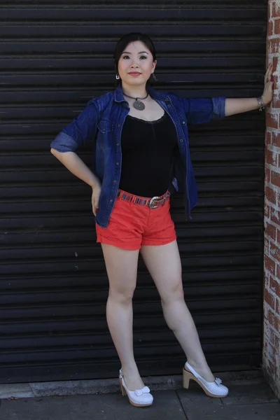 Asian model posing in front of garage door. — Stock Photo, Image