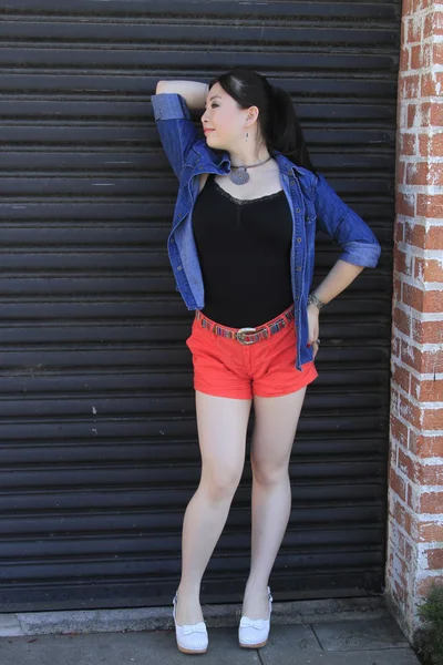 Asian model posing in front of garage door. — Stock Photo, Image