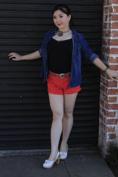 Asian model posing in front of garage door. — Stock Photo, Image