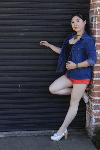 Азиатская модель позирует перед дверью гаража . — стоковое фото
