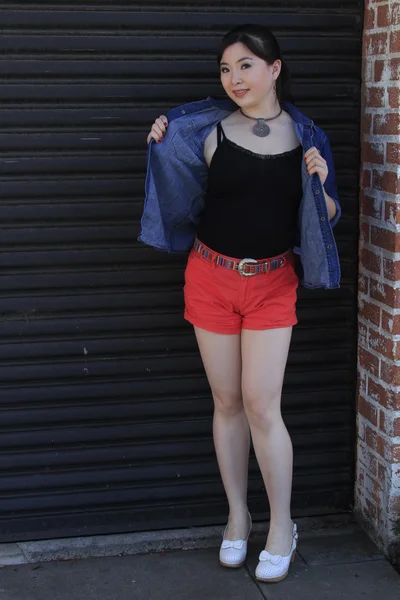 Asian model posing in front of garage door. — Stock Photo, Image