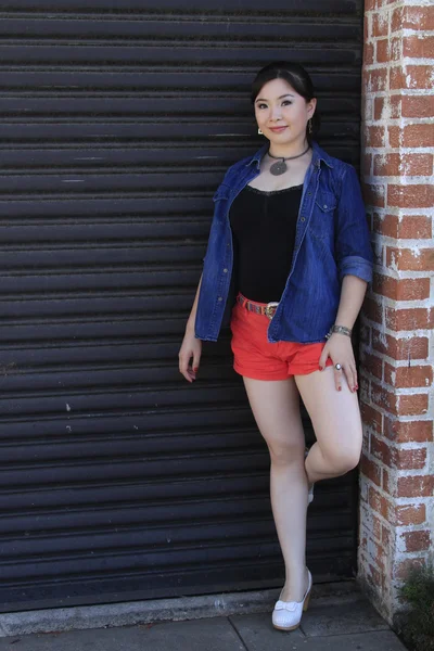 Asian model posing in front of garage door. — Stock Photo, Image