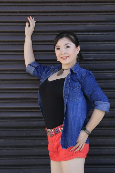 Asian model posing in front of garage door. — Stock Photo, Image