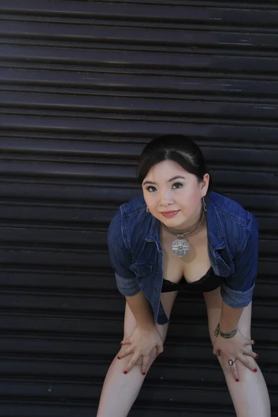 Asian model posing in front of garage door. — Stock Photo, Image