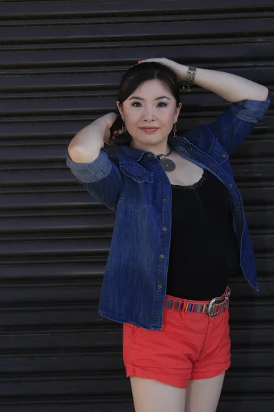 Asian model posing in front of garage door. — Stock Photo, Image