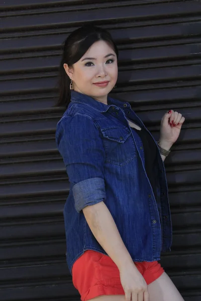 Asian model posing in front of garage door. — Stock Photo, Image