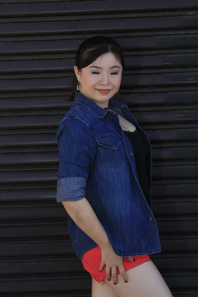 Asian model posing in front of garage door. — Stock Photo, Image