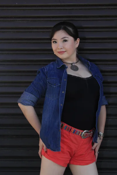 Asian model posing in front of garage door. — Stock Photo, Image