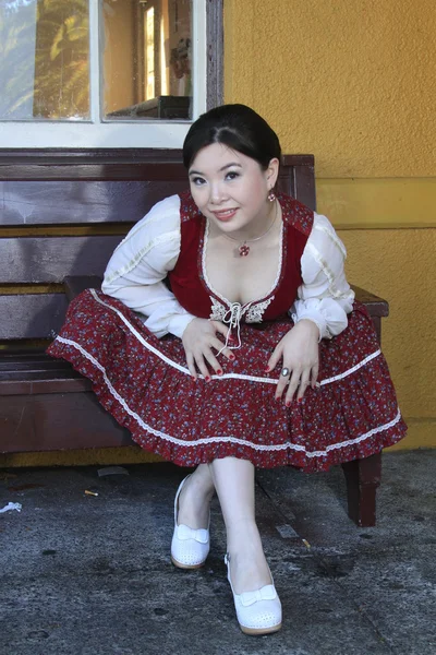 Vintage style barmaid sitting on bench — Stock Photo, Image