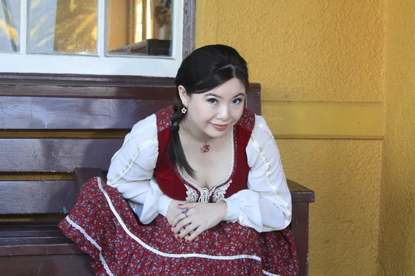 Vintage style barmaid sitting on bench — Stock Photo, Image