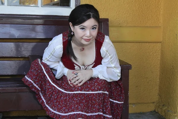 Vintage style barmaid sitting on bench — Stock Photo, Image