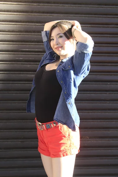 Asian model posing in front of garage door. — Stock Photo, Image