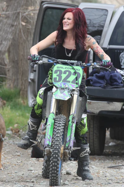 Beautiful brunette biker girl on the bike — Stock Photo, Image