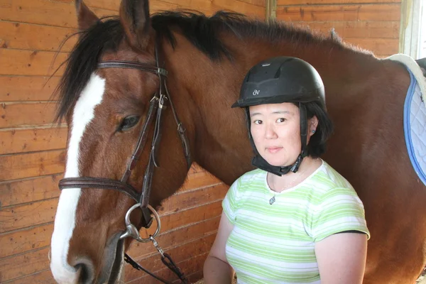 亚裔女子和一匹马在马厩里 — 图库照片