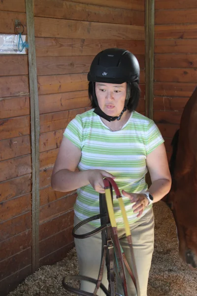 Aziatische vrouw met een paard in de stal — Stockfoto