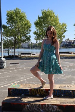 Grafitti 'nin yanındaki güzel elbiseli güzel beyaz bir kızın fotoğrafı.