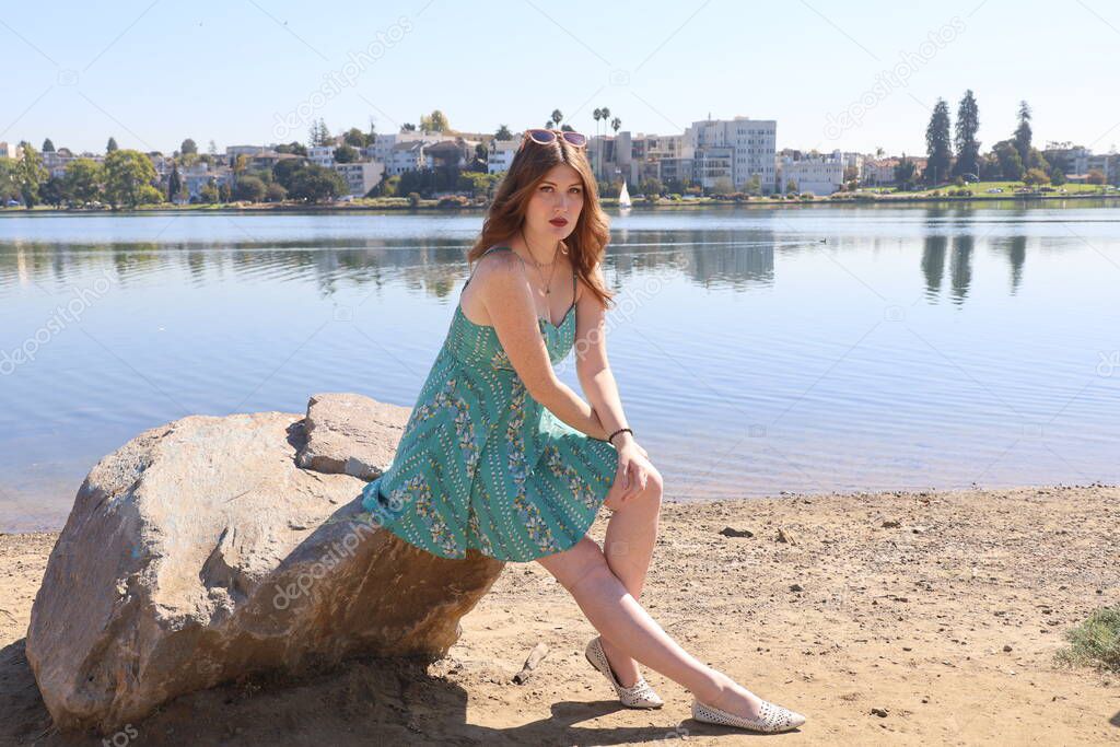 Photo of a Beautiful white girl in a beautiful dress in front of a lake