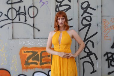 Gölün önünde duran güzel elbiseli güzel beyaz bir kızın fotoğrafı.