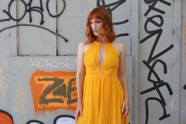 Gölün önünde duran güzel elbiseli güzel beyaz bir kızın fotoğrafı.