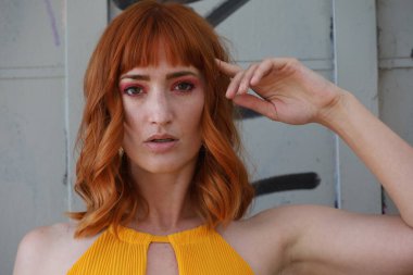 Gölün önünde duran güzel elbiseli güzel beyaz bir kızın fotoğrafı.