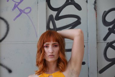 Gölün önünde duran güzel elbiseli güzel beyaz bir kızın fotoğrafı.