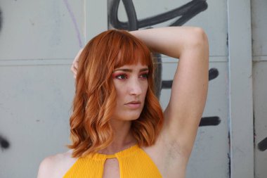 Gölün önünde duran güzel elbiseli güzel beyaz bir kızın fotoğrafı.