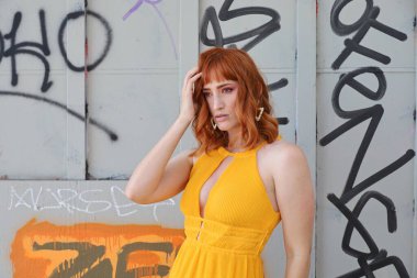 Gölün önünde duran güzel elbiseli güzel beyaz bir kızın fotoğrafı.