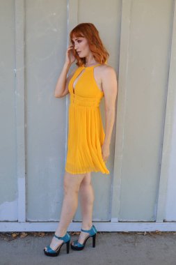 Gölün önünde duran güzel elbiseli güzel beyaz bir kızın fotoğrafı.