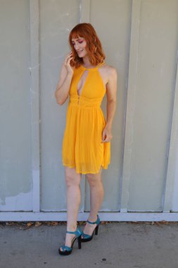 Gölün önünde duran güzel elbiseli güzel beyaz bir kızın fotoğrafı.