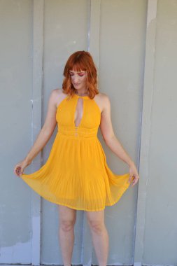 Gölün önünde duran güzel elbiseli güzel beyaz bir kızın fotoğrafı.