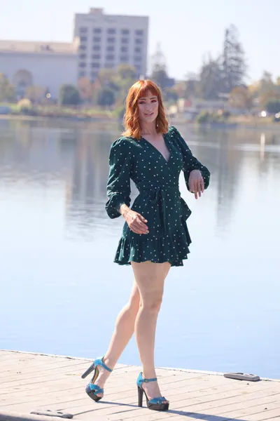 湖の前に立って美しいドレスを着た美しい白い女の子の写真 — ストック写真