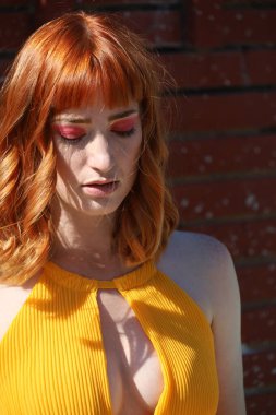 Gölün önünde duran güzel elbiseli güzel beyaz bir kızın fotoğrafı.